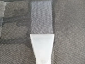 Zbliżenie na wyzcyszczoną część siedziska fotela tapicerowanego w aucie.