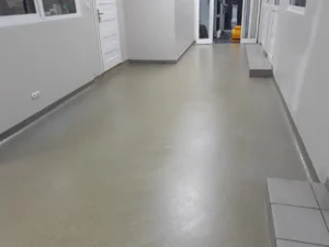 Hol firmy klienta z wykładziną PCV po wyczyszczeniu i naprawieniu uszkodzeń za pomocą polimeru akrylowego.