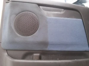 Wyprana tapicerka boczku drzwi w samochodzie. Pół na pół dla większego kontrastu.