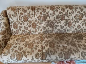 Na zdjęciu widać do połowy wypraną kanapę starego typu.